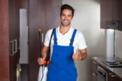 Pest control technician working in kitchen thumbs up